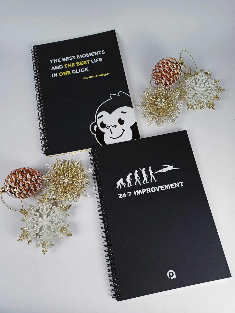 Two different A4 notebooks with black Ispira covers, one with added yellow foil and black gloss foil