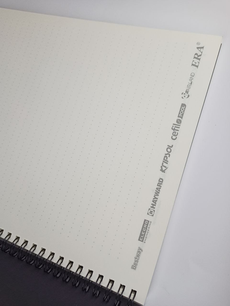 Black wire binding and an open spread of the inner block on cream Munken paper 90 gsm