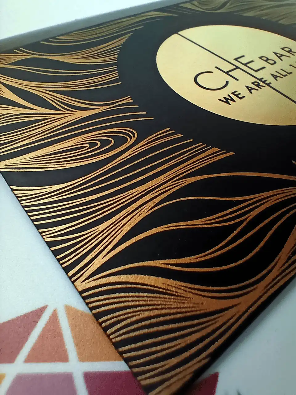 Detail of the bronze pattern on a black designer board envelope